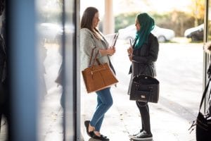 students talking at entrance to university