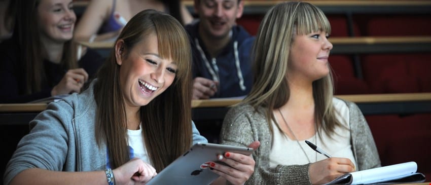 students in a lecture looking at iPad