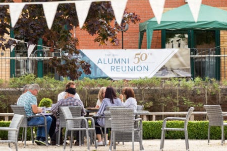 Alumni sitting outside in the quad during 50th celebrations