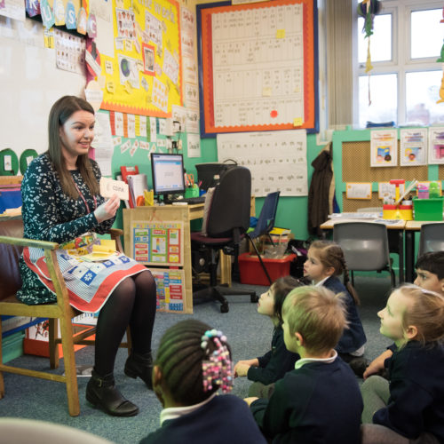 Primary school teacher talking to pupils