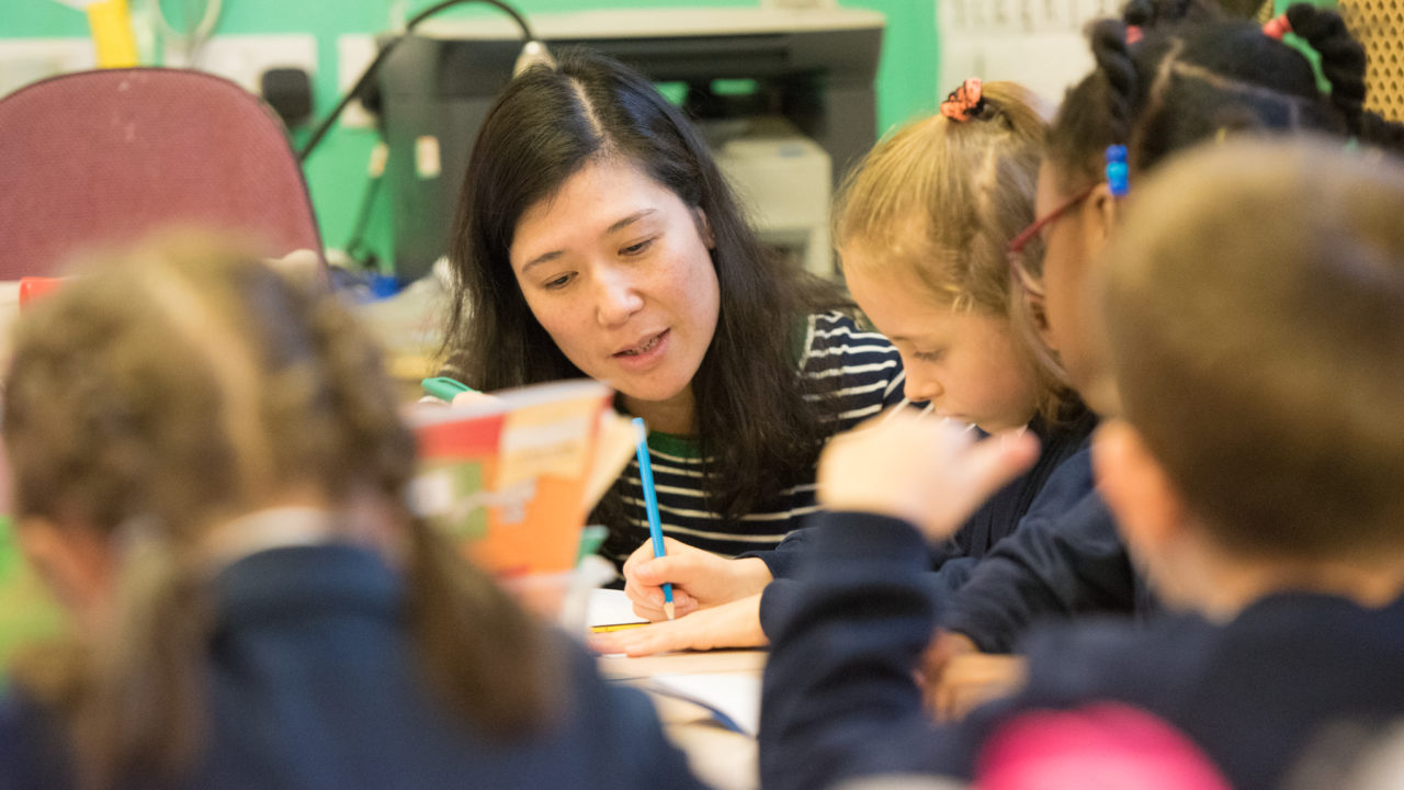 primary school teacher talking to children