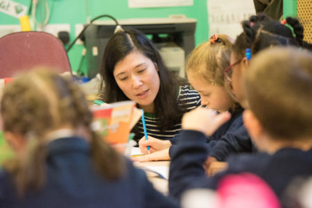 primary school teacher talking to children