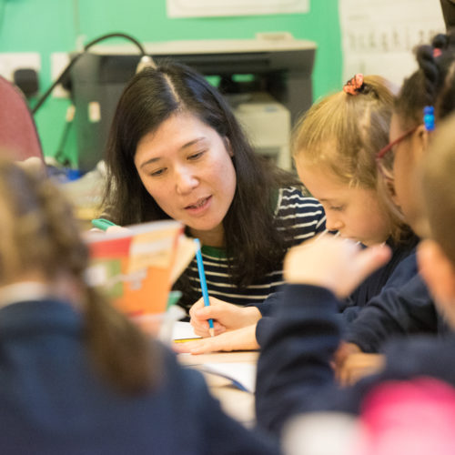 primary school teacher talking to children