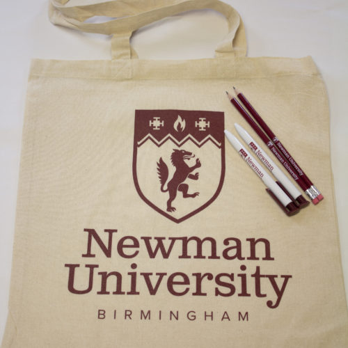 Newman branded merchandise including bag, pens and pencils