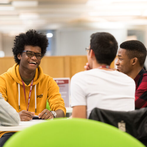 students sat at a table talking and laughing