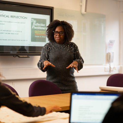 youth and community work seminar with lecturer stood at the front speaking with students