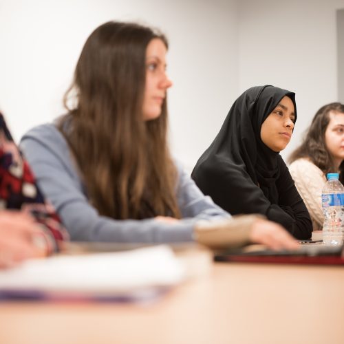 Students in a classroom using their laptop for lesson