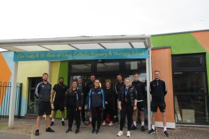 PGCE PE students standing outside a local primary school