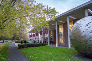 Newman front of campus with welcome flags - small