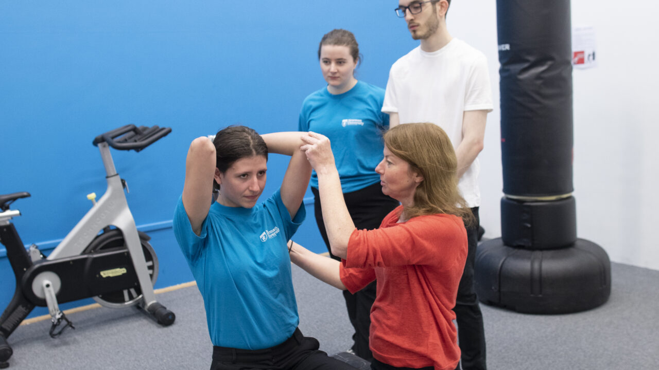Physiotherapy students with lecturer doing exercises