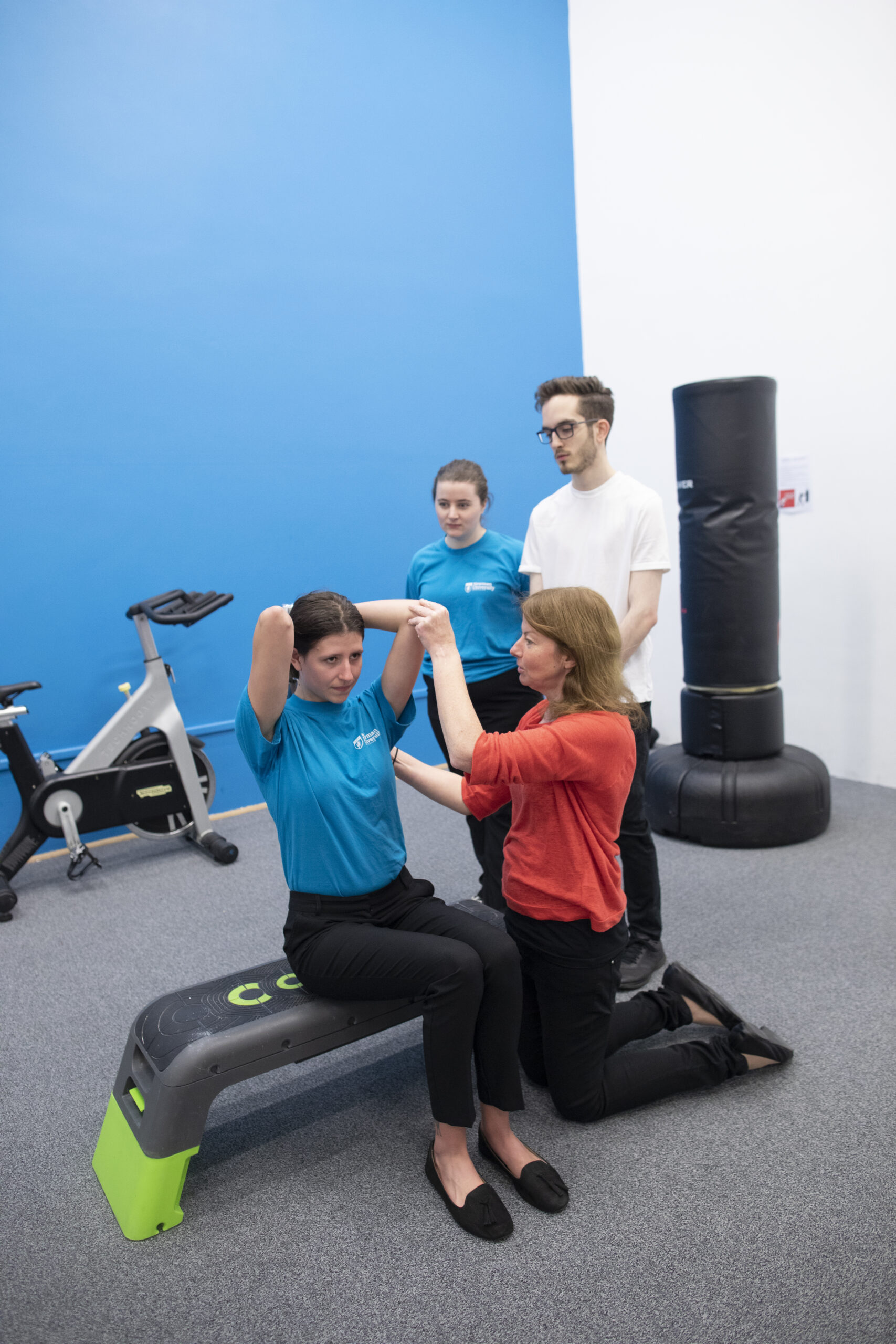Physiotherapy students with lecturer doing exercises