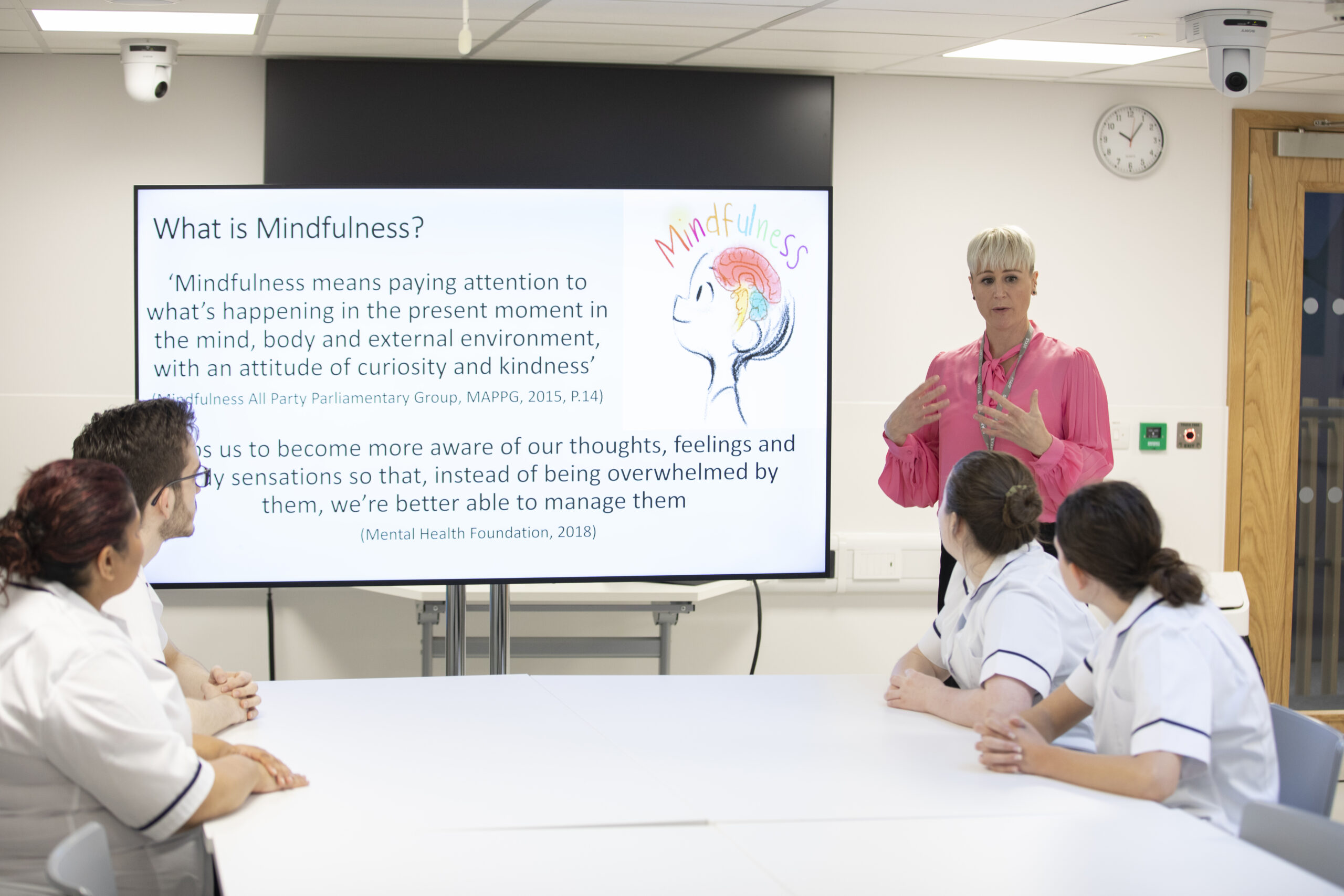 Lecturer using presentation screen to discuss mindfulness with nursing students