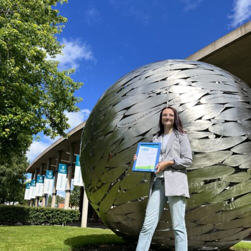 Environmental Advisor Lucy Clarke holding Bronze accreditation certificate for university travel plan