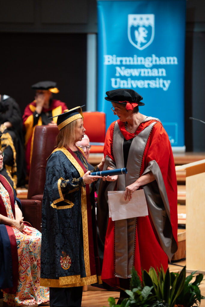 Dr Dawn Casserly receiving honorary degree from VC on stage