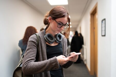 Student in corridor on mobile phone