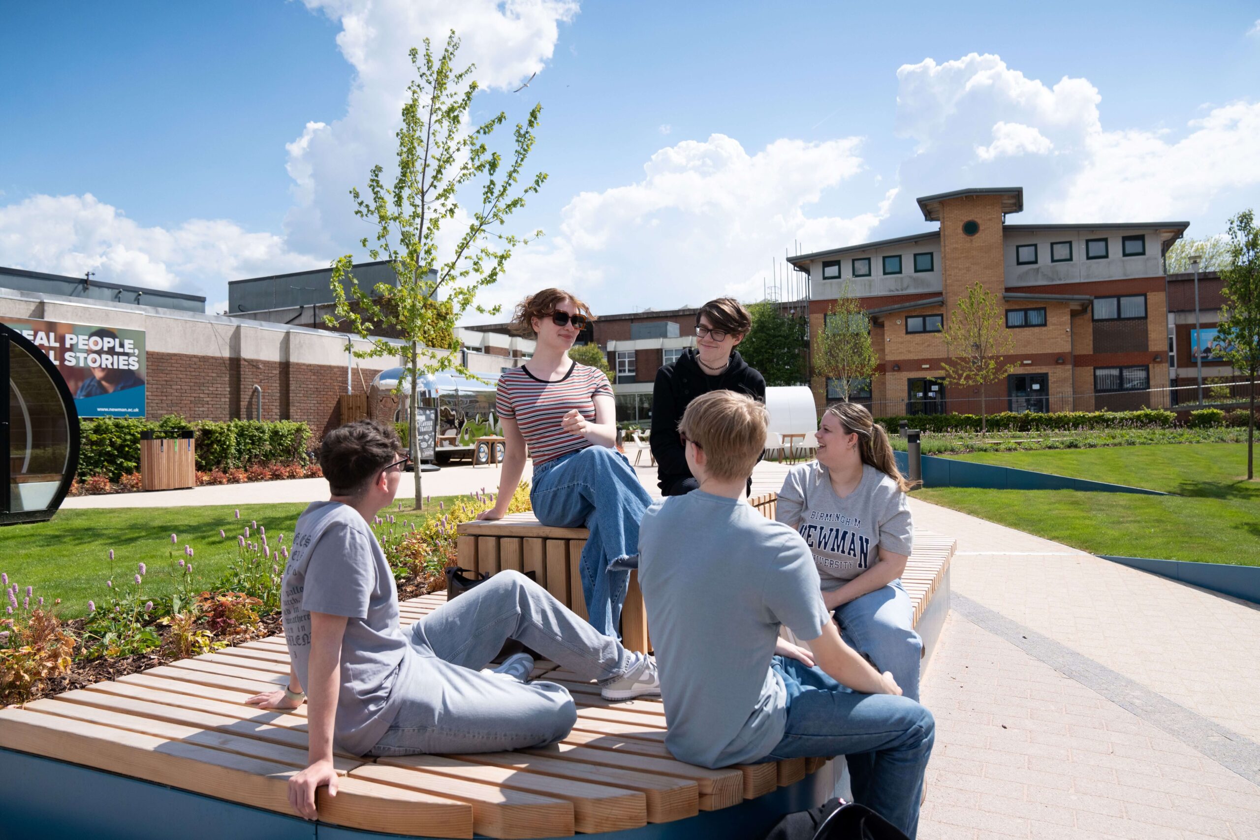 a group of people sitting on a round wooden bench outside